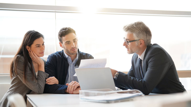 coppia parla con uomo in giacca e cravatta